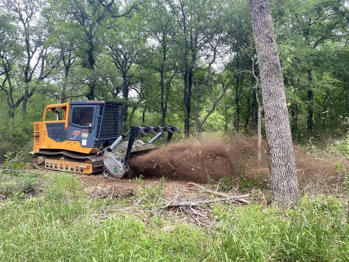 Forestry mulching and land clearing equipment at work on a Norman-area property
